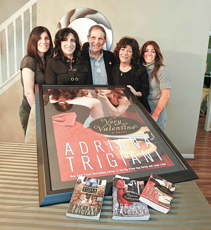 ALL IN THE FAMILY: Members of the Vechiarelli family, from left, daughters Amy Mancini and Beth Vechiarelli-Cooper, parents Dominic and Carol Vechiarelli and daughter Nanette Ungaro gather around a framed and signed poster of one of best-selling author Adriana Trigiani’s books. One of the characters in Trigiani’s last two books is named Dominic Vechiarelli for the Boardman man.