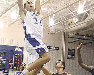 Poland's David Baker (21) flies to the rim to slam home two points as Niles Cory Floyd (2) looks on during their game Tuesday night in Poland.