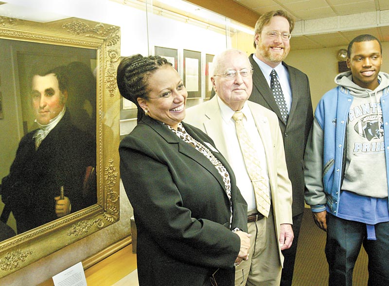 William D. Lewis/The Vindicator l-r Dr. Wendi Webb, Y-town Schools Supt. Charles Rudibaugh, Rayen Foundation President, William Lawson of Arms Museum and East HS senior Brandon Mosley, who was a freshman at Rayen before it was closed look over items at the Rayen exhibit at the Arms Museum. Portrait of Judge William Rayen is at left.