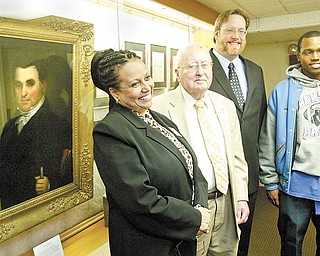 William D. Lewis/The Vindicator l-r Dr. Wendi Webb, Y-town Schools Supt. Charles Rudibaugh, Rayen Foundation President, William Lawson of Arms Museum and East HS senior Brandon Mosley, who was a freshman at Rayen before it was closed look over items at the Rayen exhibit at the Arms Museum. Portrait of Judge William Rayen is at left.