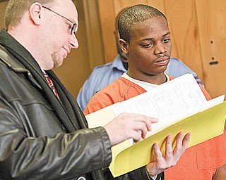 PAPERWORK: Jamar Houser, 19, right, looks over copies of the charges against him with his lawyer, Atty. Michael Villani, in Youngstown Municipal Court. Houser, a suspect in a murder case, was sentenced Thursday to 90 days in Mahoning County jail on unrelated charges of disorderly conduct and criminal damaging.