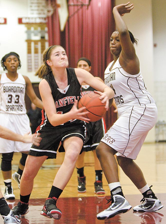Canfield's Sabrina Mangapora (44) drives to the hoop past Boardman's  Darryce Moore (44) only to be fouled during the third quarter of a game at Boardman High School on Thursday evening.
