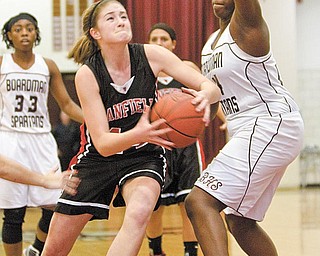 Canfield's Sabrina Mangapora (44) drives to the hoop past Boardman's Darryce Moore (44) only to be fouled during the third quarter of a game at Boardman High School on Thursday evening.
