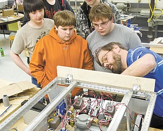 A WIRING LESSON: Teacher adviser Gordon Powell, far right, shows the Liberty High School robotics team how to run wire through drilled holes. Team members watching, from center going counterclockwise, are: Carter Brady, 15; Nate Purnell, 17; Steve Struble, 16; Rick Palmer, 15; and Adam Clare, 14.