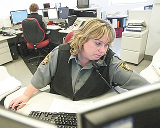 COLUMBIANA UPGRADES: Jennifer Swords, a Columbiana County 911 dispatcher, handles a call. The county is upgrading its 911 emergency telephone service so that it can handle calls made from cellular phones.