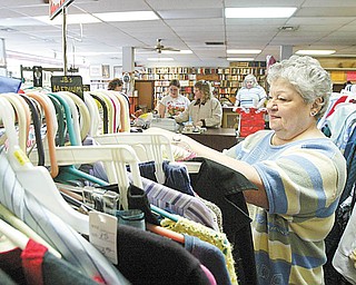 THRIFT STORE: Mary Henley straightens items in a rack at the Second Blessing Thrift Store in Salem. Henley is assistant manager of the store, which features clothes, used appliances and more.