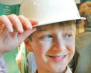 William D. Lewis/The Vindicator Chance Retino,a student at the University School in Shaker Hgts dons a hard hat during a recent tour of the Steel Museum. students from his school visit the museum each year.