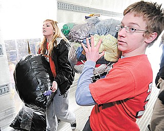 Girard 11th grader Abbie Hall (L) and Girard 12th grader Max Horne both members of Robo Cats help load a truck full of supplies for Haiti on Saturday as part of a Girard Liberty Rotary. Photo/Mark Stahl