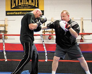 Kelly Pavlik spars with trainer Jack Loew at the South Side Boxing gym in preparation for his title defense.