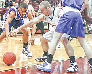 Salem’s Trent Toothman (12) and Ravenna’s Stephen Wilmington (21) chase the ball during the first period of their Division Ii basketball sectional Tuesday at Boardman High School. The Eagles cruised past the Quakers, 51-48.