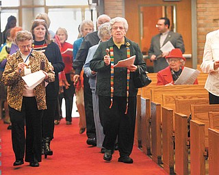 Participants for a World Day of Prayer service Thursday, wearing colorful scarves and animal-print clothing, play rattles, tambourines, shakers and bells as they walk up the aisle of Bethel Lutheran Church in Boardman. Leading are Joyce Rettenmeir, left, and Ruth Abbott. Their apparel and instruments were a tribute to the women of Cameroon, Africa, who wrote the ecumenical service.