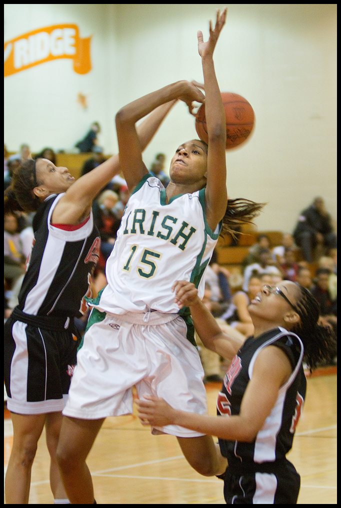 Geoffrey Hauschild|The Vindicator.Ursuline's Dominique Jenkins (15) meets resistence on her way to the hoop from Campbell's Tashira Uceta (1) and Jayaira Grhim (15) during the third quarter at Mineral Ridge High School on Saturday afternoon.