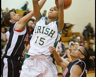 Geoffrey Hauschild|The Vindicator.Ursuline's Dominique Jenkins (15) meets resistence on her way to the hoop from Campbell's Tashira Uceta (1) and Jayaira Grhim (15) during the third quarter at Mineral Ridge High School on Saturday afternoon.
