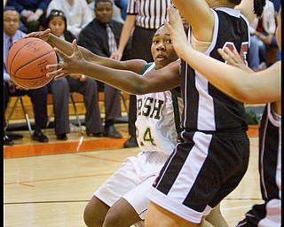 Geoffrey Hauschild|The Vindicator.Ursuline's Briana Curd (24) keeps the ball at a safe distance from Campbell's Tiffany Colon (25) while driving to the basket during the third quarter at Mineral Ridge High School on Saturday afternoon.