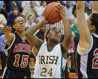 Geoffrey Hauschild|The Vindicator.Ursuline's Briana Curd (24) takes aim while defended by Campbell's Jayaira Grhim (15) and Tiffany Colon (25) during the third quarter at Mineral Ridge High School on Saturday afternoon.