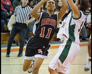 Geoffrey Hauschild|The Vindicator.Campbell's Brande Ellington (11) tries for a layup against Ursuline's Ja'Nice Whitehead (14) during the fourth quarter at Mineral Ridge High School on Saturday afternoon.