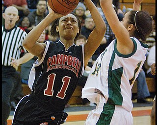 Geoffrey Hauschild|The Vindicator.Campbell's Brande Ellington (11) tries for a layup against Ursuline's Ja'Nice Whitehead (14) during the fourth quarter at Mineral Ridge High School on Saturday afternoon.