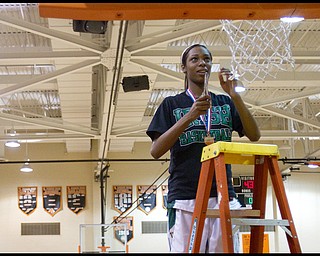 Geoffrey Hauschild|The Vindicator.Ursuline's Dominique Jenkins (15) cuts off a piece of the net following a victory against Campbell at Mineral Ridge High School on Saturday afternoon. After winning, the team wore shirts in support of Uruline's boys basketball player Jordan Dubose (45) who was recently diagnosed with a serious illness.