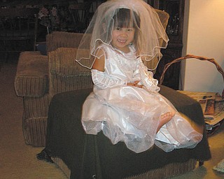 Jenni-Lin HuaYi Remias, granddaughter of Norma Remias of Canfield, is playing dress-up in her bridal outfit that was a Christmas present. She resembles the barefoot bride!
