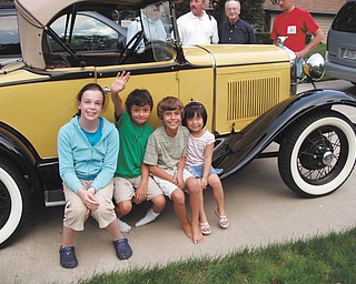 This is a photo of a 1930 Ford Model ÒAÓ taken by owner R.J.Wittenauer of Boardman.The children were taken for a ride on this day and are as follows, from left: Lauren McIntosh of Poland, Christian and Connor McIntosh, both of North Jackson, and Jillian McIntosh of Poland. In the background are, from left, Dr. Robert McIntosh, father of Christian and Connor; William McIntosh, the childrenÕs grandfather; and James McIntosh, father of Lauren and Jillian..