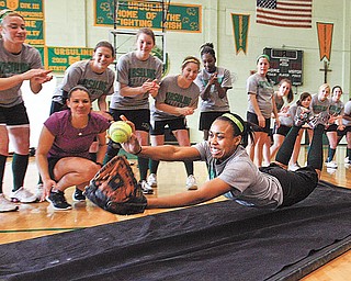 GIRL Magazine sponsored a visit by Olympic softball gold medalist Jessica Mendoza, second from left, to Ursuline High School on Tuesday. Mendoza spent the day talking to the Ursuline players about running, sliding, hitting, diving, bunting and other techniques to become a better softball player and athlete, as demonstrated by Ursuline player Malikka Cage, foreground. Cage initiated Mendoza’s visit, writing to ESPN and inviting them to come to the school.