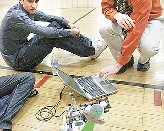 Faisal Mangalji, left, and Shaun Hardin, both seniors and members of the Howland High School robotics team, use a computer to adjust their robot, Jeffrey, for the 12th Northeast Ohio Robotics Education Program competition. The team and Jeffrey took the overall top prize in the high school division at Wednesday’s event at Youngstown State University.