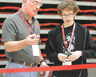 Marty Fernpack, left, committee member and judge, and Jarret Scacchetti, a Youngstown State University student, check the size of the block to be moved by robots.