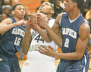 William D.Lewis| The Vindicator Hardings Oneal Brown keeps the ball from Garfield'sMike Davis, left and Tony Farmer.