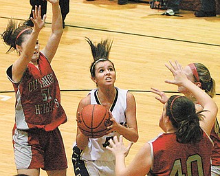 ROBERT K. YOSAY | THE VINDICATOR ..Lowellvilles #5 sophmore Ashley Moore is surrounded as she goes for two by Cuyahoga #40 Carly Stock #44 (hidden) Brianna Stock and #51 Brooke Rayokovich during second quarter action= as Lowellville Lady Rockets played the Cuyahoga Lady Redskins at Massilon Perry High School Thursday night in playoff action - 30-
