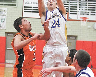 BOYS BBALL - (24) Matthias Tayala shoots over (33) Jalen DeSarro during their game Monday night in Struthers. - Special to The Vindicator/Nick Mays