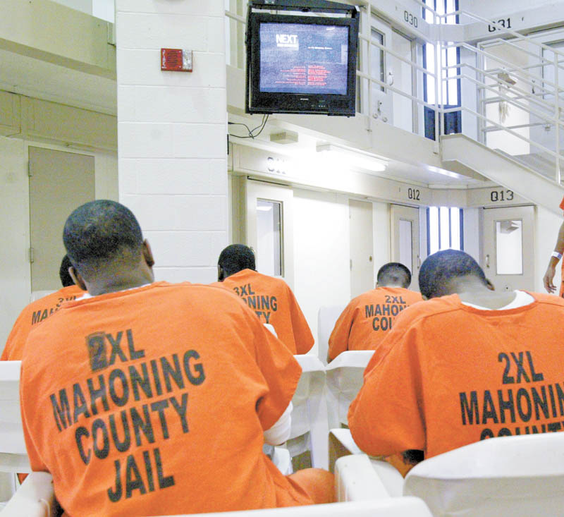Inmates sit in a television-viewing pod at the Mahoning County jail in downtown Youngstown. County officials will be in federal court in Cleveland on Wednesday, seeking permission to close half the jail and lay off one-third of the sheriff’s staff, effective March 28.
