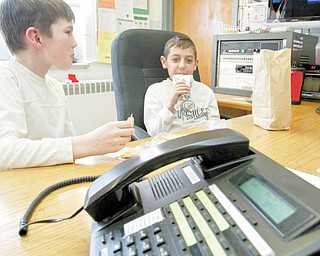 Lloyd Elementary third-graders Ethan Cochran, left, and Blake Kusky man the phones during their lunch period each day. Students in each of the Austintown School District buildings are chosen to help answer phones at their respective school. Ethan said it’s one of the most sought-after student jobs at Lloyd.