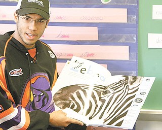 Jordan Tibbett, a goalie for the Youngstown Phantoms, reads “Life Size Zoo” to third-graders at Lloyd Elementary in Austintown. Tibbett, along with nine of his teammates, read to students in first, second and third grade Tuesday afternoon.