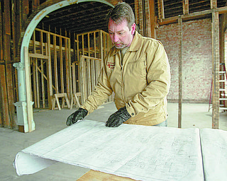 William D. Lewis|The Vindicator Paul Clouser, owner of National Fire Repair, looks over plans in an old building he is restoring on W.Market St in downtown Warren. The building will host National Fire Repair's offices on the first floor and l apartments on the 2nd floor. Clouser is making an apartment on the3 rd floor for he and his wife.