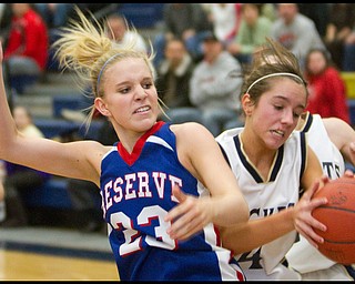 The Vindicator/Geoffrey Hauschild.Lowellville's Kaye Solak (4) grabs the ball away from Western Reserve's Hannah Mowery (23) while going for a rebound during the third quarter of a game at Lowellville High School on Monday evening.
