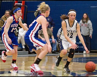 The Vindicator/Geoffrey Hauschild.Lowellville's Taylor Hvisdak (12) drives down court while defended by Western Reserve's Colleen Kennehan (10) and teamate Hannah Mowery (23) during the fourth quarter of a game at Lowellville High School on Monday evening.