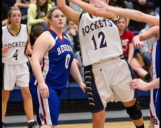 The Vindicator/Geoffrey Hauschild.Lowellville's Taylor ?Hvisdak? (12) takes a shot as Western Reserve's Sammi Burton (0) looks on from the background during the fourth quarter of a game at Lowellville High School on Monday evening.