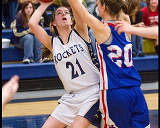 The Vindicator/Geoffrey Hauschild.Lowellville's Kelley Hunes (21) takes a shot from beneath the basket past Western Reserve's Hannah Shrader (20) during the fourth quarter of a game at Lowellville High School on Monday evening.