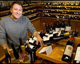 The Vindicator/Geoffrey Hauschild.President of Vintage Estate, Phil Reda, poses for a portait with some of the more than 1,000 types of wine at Vintage Estate along South Ave. on Tuesday afternoon.