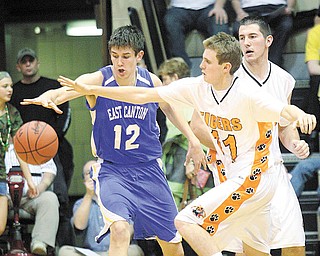 C.J. Peaco, right, of Newton Falls and Stuart Campbell of East Canton go after a loose ball during the Division III regional semifinal basketball game at the Canton Fieldhouse on Wednesday night. Newton Falls advanced with a 60-48 win.