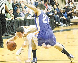 BBALL - Cody Dillion looses his balance as (24) Jon Cartwright plays defense Wednesday night in Canton. - Special to The Vindicator/Nick Mays