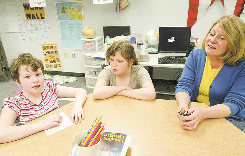 William D. Lewis| The Vindicator  Rich Center teacher Patty Fisher, right, works with students Morgan Kerr, 9, left, and Rebecca Miller, 10 at  the Rich Center at YSU 3-19-10.