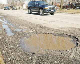 William D. Lewis/the Vindicator  Motorists dodge a large pot hole on Fifth Avenue in Youngsotwn Monday March 8, 2010.