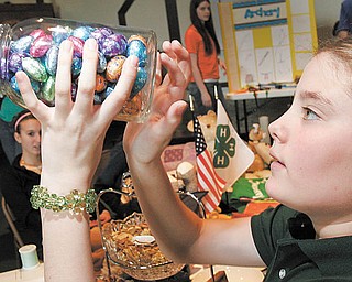 William D. Lewis| The Vindicator Sarah Veverka, 10, of Canfield and a member of the Greenford Busy Bees 4-H club tries to guess the number of chocolates in a jar during  4-H community Day at Lord of Life Luthern Church in Canfield Saturday 3-20-10.