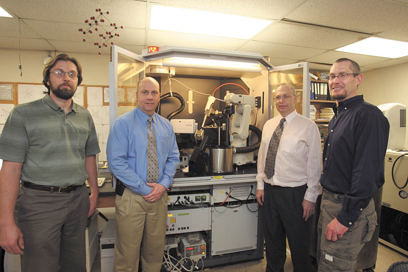 Officials stand near laboratory equipment at Youngstown State University that led Zethus Software of Youngstown to form a partnership with the German company that makes the equipment. Shown are Andre Reinhardt, Zethus co-founder, left; Brad Myers, Zethus chief executive; Allen Hunter, YSU chemistry professor; and Eric Parker, Zethus co-founder.