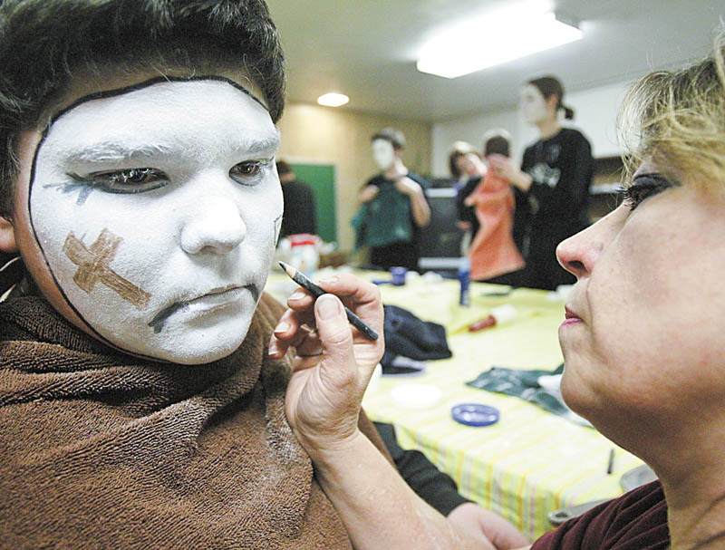Jacob Seink, 13, of Newton Falls waits patiently as his mother, Amy, applies his makeup for the spiritual mime ministry "For You, For Me." The traveling troupe, which involves from 15 to 20 seventh- and eighth-graders from Lake Milton, Newton Falls and North Jackson, is presenting the Passion of Christ at various sites.