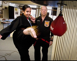 The Vindicator/Geoffrey Hauschild2.19.2010Heather Powell, 17 of Youngstown, kicks a bag alongside instructor, Todd Vea, during a karate lesson at AE Vea Karate along Belmont Ave. in Youngstown on Friday afternoon.