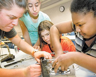 Second-year Youngstown State University civil engineering major Micelle Stipetich, from left, helps Liberty sixth-graders Haneen Kotb, 12, Jordyn Faustino, 11, and Teshaia Cain, 11, disassemble a toaster during Tear Apart A Toaster. The Thursday event at YSU's Moser Hall was arranged by the university's Society of Women Engineers. Stipetich helped organize the event.