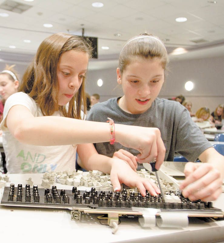 Liberty sixth-graders Isabella Nunu, 12, left, and Courtney Weimer, 11, take apart a computer keyboard during Tear Apart a Toaster Thursday at Youngstown State University’s Moser Hall. YSU’s Society of Women Engineers arranged the event.