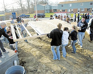 Habitat for Humanity volunteers move walls into place while working on a house on Maranatha Drive in Youngstown.